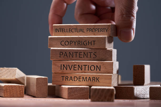 istockphoto-1422564173-612x612 man adding a block showing the words Intellectual property on top of other wooden block with text copyright, patents, invention,and trademark